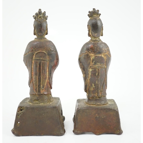 152 - A pair of Chinese Ming bronze figures of attendants, each figure standing and holding an offering in... 