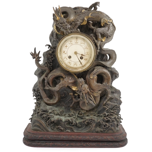 168 - A Japanese parcel gilt bronze dragon mantel clock, Meiji period, modelled with two dragons amongst... 