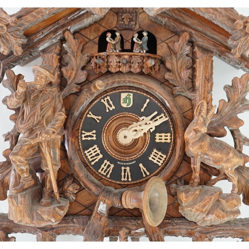 179 - A Hönes Black Forest carved wood cuckoo clock with eagle finial, alpine climber and Chamonix figures... 