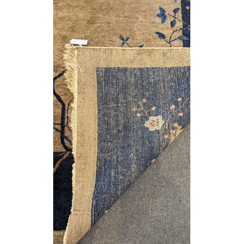 185 - A Walter Nichols Chinese champagne ground carpet with asymmetrical decoration of flowers and an urn,... 