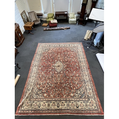 187 - A Sarouk carpet, with central medallion and field of foliate motifs on a brick red ground 430 x 320c... 