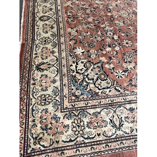 187 - A Sarouk carpet, with central medallion and field of foliate motifs on a brick red ground 430 x 320c... 