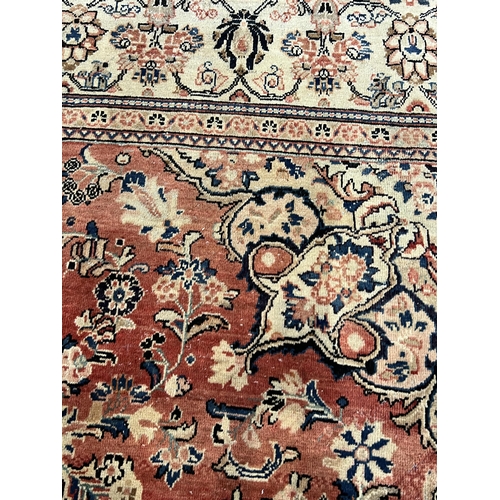 187 - A Sarouk carpet, with central medallion and field of foliate motifs on a brick red ground 430 x 320c... 