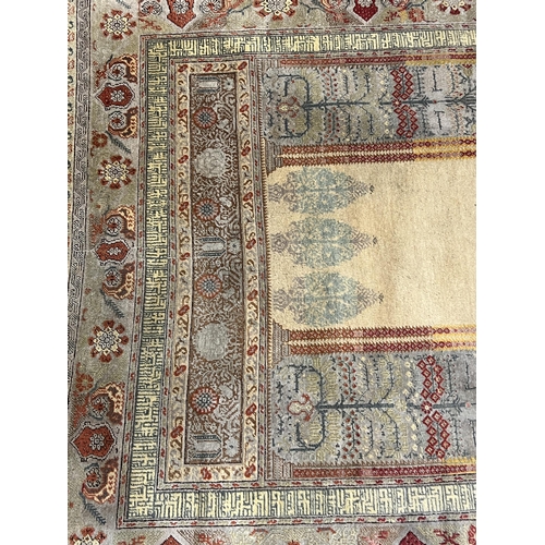 192 - A Turkish silk prayer rug, with central mihrab and stylised floral borders, 205 x 122cm