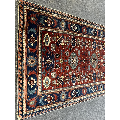 193 - A Shiraz rug, the red field, decorated with flowerheads and geometrical devices, with multiple borde... 