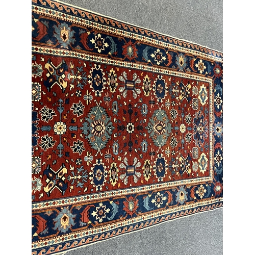 193 - A Shiraz rug, the red field, decorated with flowerheads and geometrical devices, with multiple borde... 