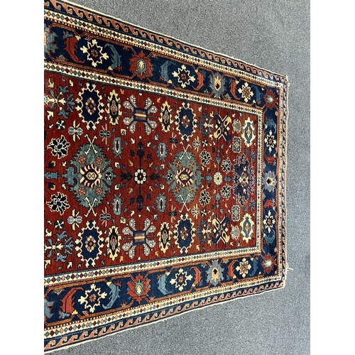 193 - A Shiraz rug, the red field, decorated with flowerheads and geometrical devices, with multiple borde... 