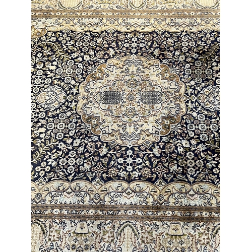 195 - A Persian silk rug, with central medallion and field of foliate motifs on a black ground, 180 x 120c... 