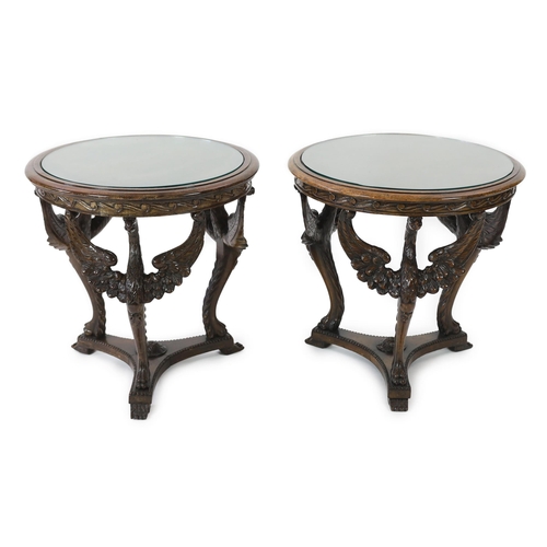 200 - A pair of walnut occasional tables with glass inset circular tops and triple winged eagle monopodia ... 