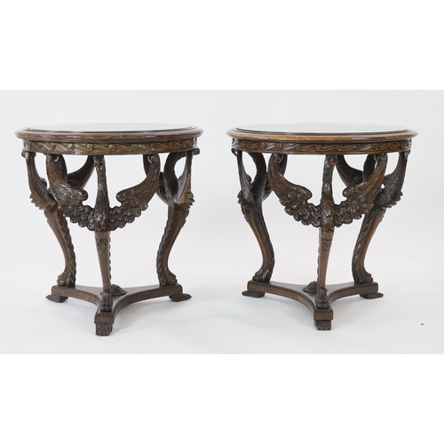 200 - A pair of walnut occasional tables with glass inset circular tops and triple winged eagle monopodia ... 