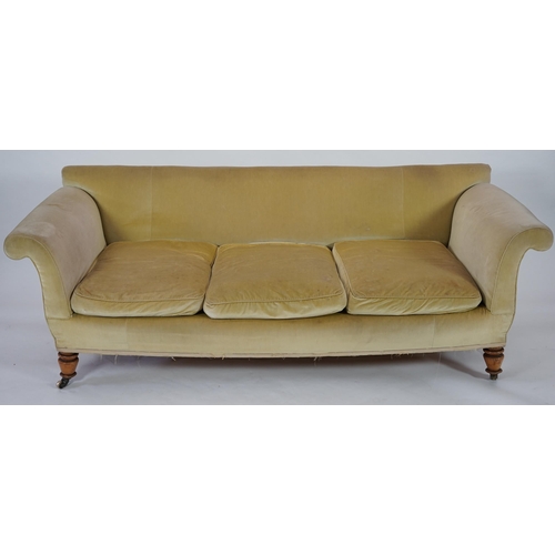 216 - A large Victorian sofa, in the manner of Howard & Sons, with faded velvet upholstery, on turned gold... 