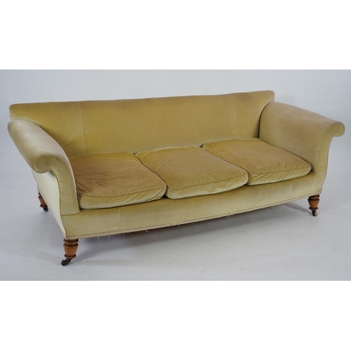 216 - A large Victorian sofa, in the manner of Howard & Sons, with faded velvet upholstery, on turned gold... 