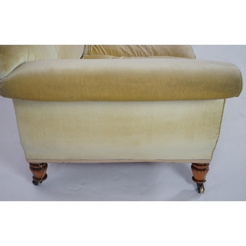 216 - A large Victorian sofa, in the manner of Howard & Sons, with faded velvet upholstery, on turned gold... 