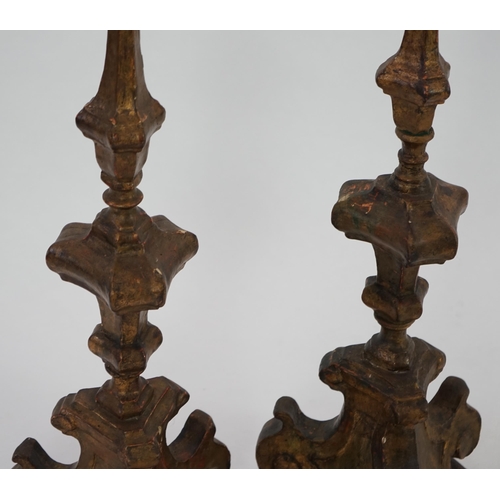 219 - A pair of 18th century Italian giltwood candlesticks with knopped triangular stems and scroll feet, ... 