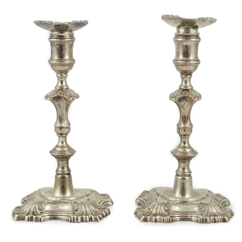 419 - A pair of George II cast silver candlesticks by William Gould, with knopped stems, on shaped square ... 