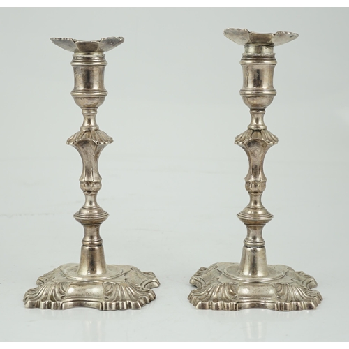 419 - A pair of George II cast silver candlesticks by William Gould, with knopped stems, on shaped square ... 