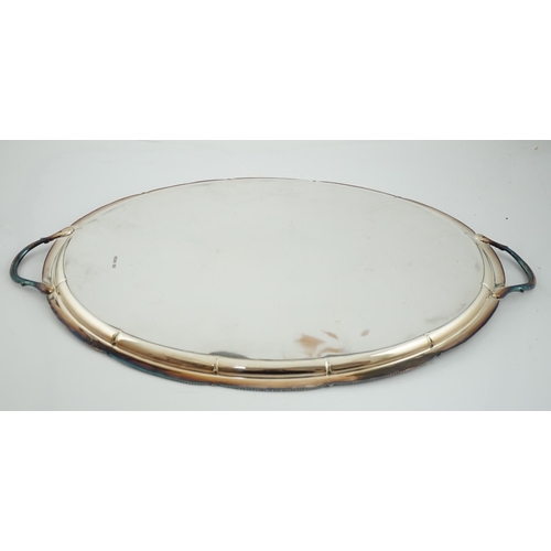 466 - An Edwardian silver oval two handled tea tray, by George Howson, with shaped gadrooned border and en... 