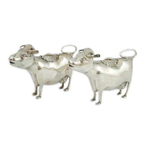 478 - A pair of Elizabeth II silver cow creamers, by Heming & Co, each with hinged cover and housefly surm... 