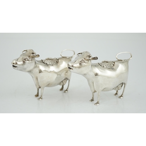 478 - A pair of Elizabeth II silver cow creamers, by Heming & Co, each with hinged cover and housefly surm... 