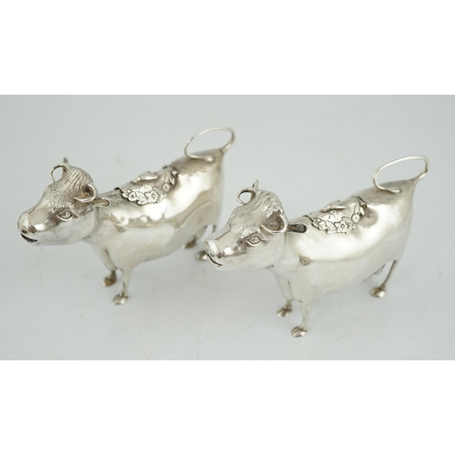 478 - A pair of Elizabeth II silver cow creamers, by Heming & Co, each with hinged cover and housefly surm... 