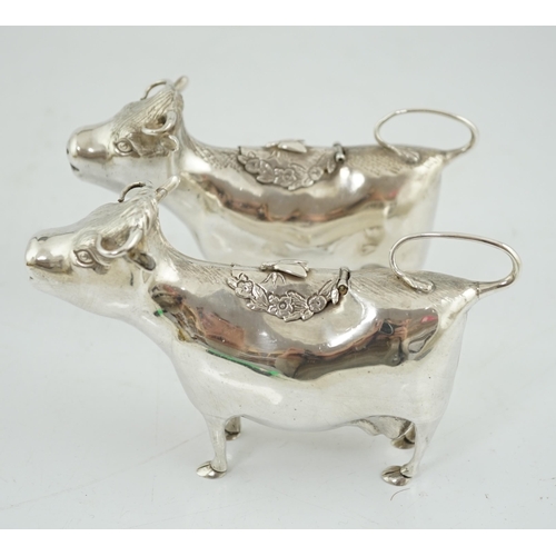 478 - A pair of Elizabeth II silver cow creamers, by Heming & Co, each with hinged cover and housefly surm... 