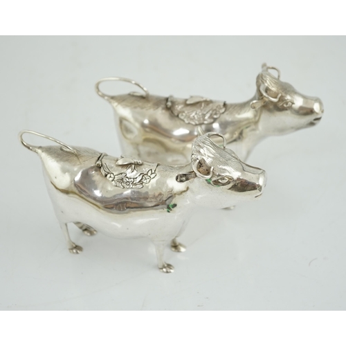 478 - A pair of Elizabeth II silver cow creamers, by Heming & Co, each with hinged cover and housefly surm... 