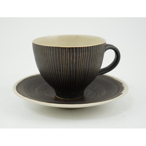 57 - Dame Lucie Rie D.B.E. (1902-1995), a manganese glazed coffee cup and saucer, the cup with incised ve... 