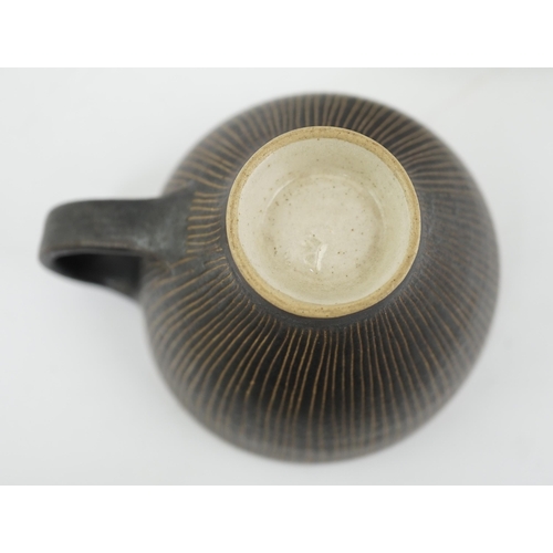 57 - Dame Lucie Rie D.B.E. (1902-1995), a manganese glazed coffee cup and saucer, the cup with incised ve... 