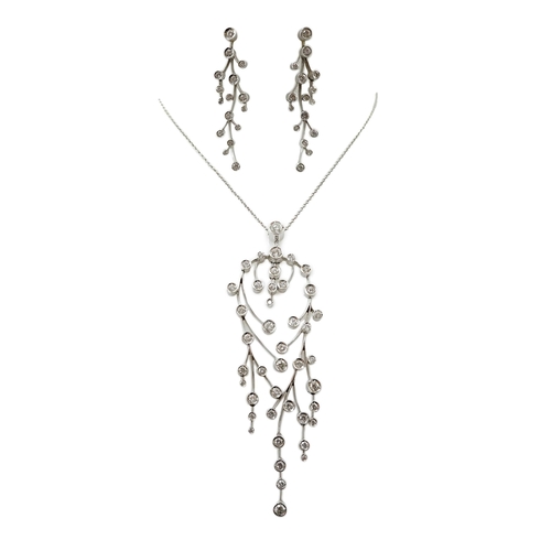 592 - A modern 18ct white gold and diamond cluster set drop pendant on chain, together with a pair of matc... 