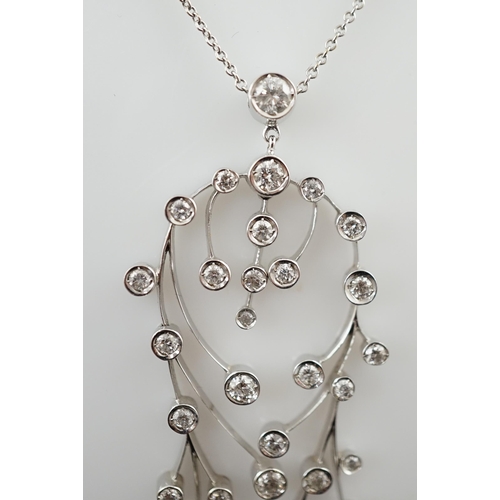 592 - A modern 18ct white gold and diamond cluster set drop pendant on chain, together with a pair of matc... 