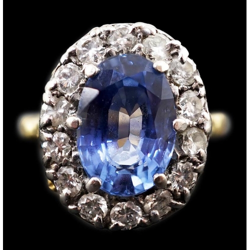 598 - An 18ct gold, sapphire and diamond set oval cluster ring, the pale blue sapphire measuring approxima... 