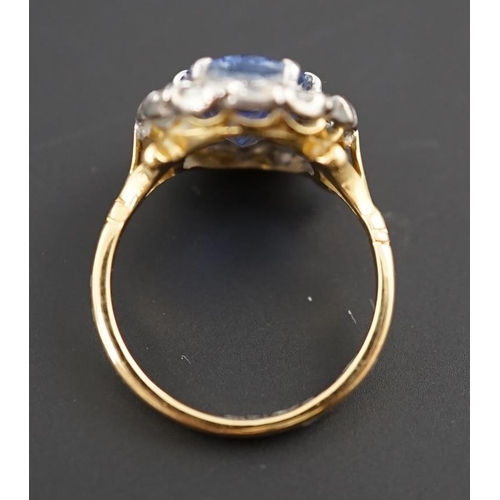 598 - An 18ct gold, sapphire and diamond set oval cluster ring, the pale blue sapphire measuring approxima... 