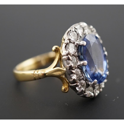 598 - An 18ct gold, sapphire and diamond set oval cluster ring, the pale blue sapphire measuring approxima... 