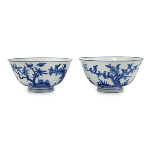 84 - A near pair of Chinese blue and white birds bowls, Kangxi period, each painted with birds amid tre... 