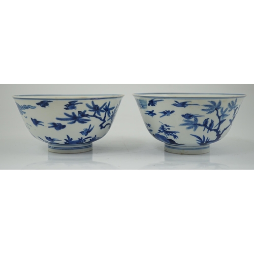 84 - A near pair of Chinese blue and white birds bowls, Kangxi period, each painted with birds amid tre... 