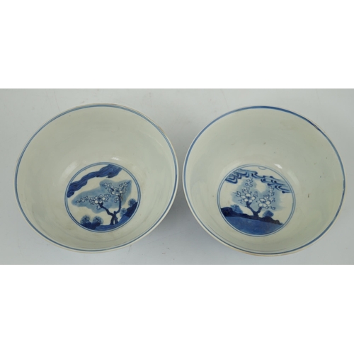84 - A near pair of Chinese blue and white birds bowls, Kangxi period, each painted with birds amid tre... 