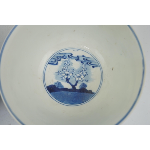 84 - A near pair of Chinese blue and white birds bowls, Kangxi period, each painted with birds amid tre... 