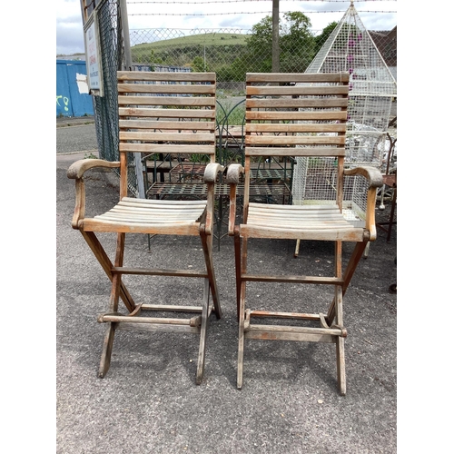 1002 - A pair of weathered teak folding garden bar chairs, width 57cm, height 130cm. Condition - fair... 