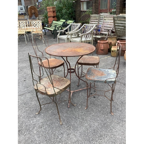 1012 - An early 20th century wrought iron garden table, diameter 70cm, height 75cm and four chairs.  Condit... 