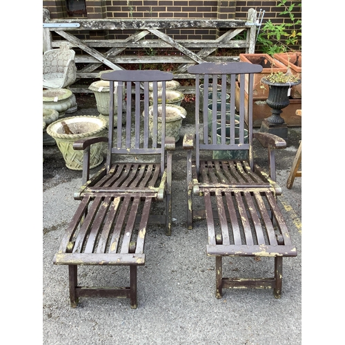1030 - A pair of stained teak garden steamer chairs. Condition - fair