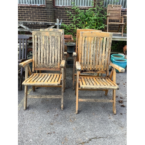 1035 - A set of four stained teak folding garden armchairs. Condition - poor