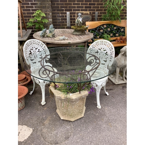 1043 - A reconstituted stone and wrought iron glass top garden planter/table, diameter 100cm, height 77cm, ... 
