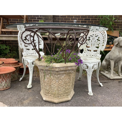 1043 - A reconstituted stone and wrought iron glass top garden planter/table, diameter 100cm, height 77cm, ... 