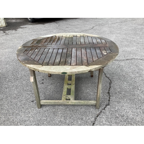 1046 - A Westminster circular weathered teak extending garden table, (leaf not functioning correctly), diam... 