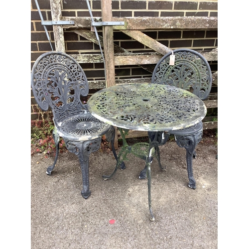 1051 - A Victorian style circular painted aluminium garden table, diameter 64cm, height 66cm, and two chair... 