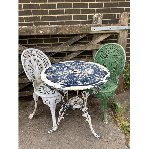 1054 - A Victorian style painted aluminium circular garden table, diameter 68cm, height 70cm and two chairs... 