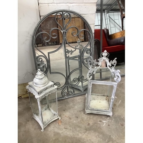 1064 - A cast metal garden wall mirror, width 50cm, height 77cm, together with two glazed metal lanterns. C... 