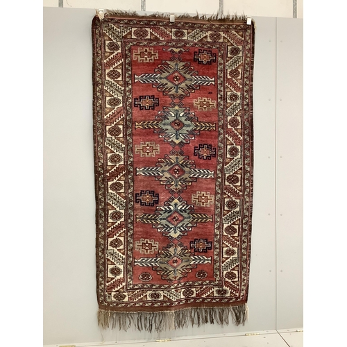 1104 - A Caucasian style red ground rug, 210 x 120cm. Condition - fair