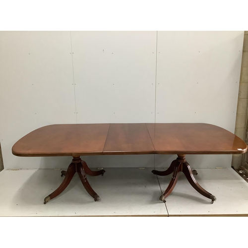 1119 - A reproduction George III style mahogany twin pillar extending dining table, 264cm extended, one spa... 