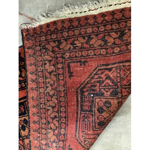 1186 - A pair of Afghan red ground rugs, each 144 x 75cm. Condition - fair